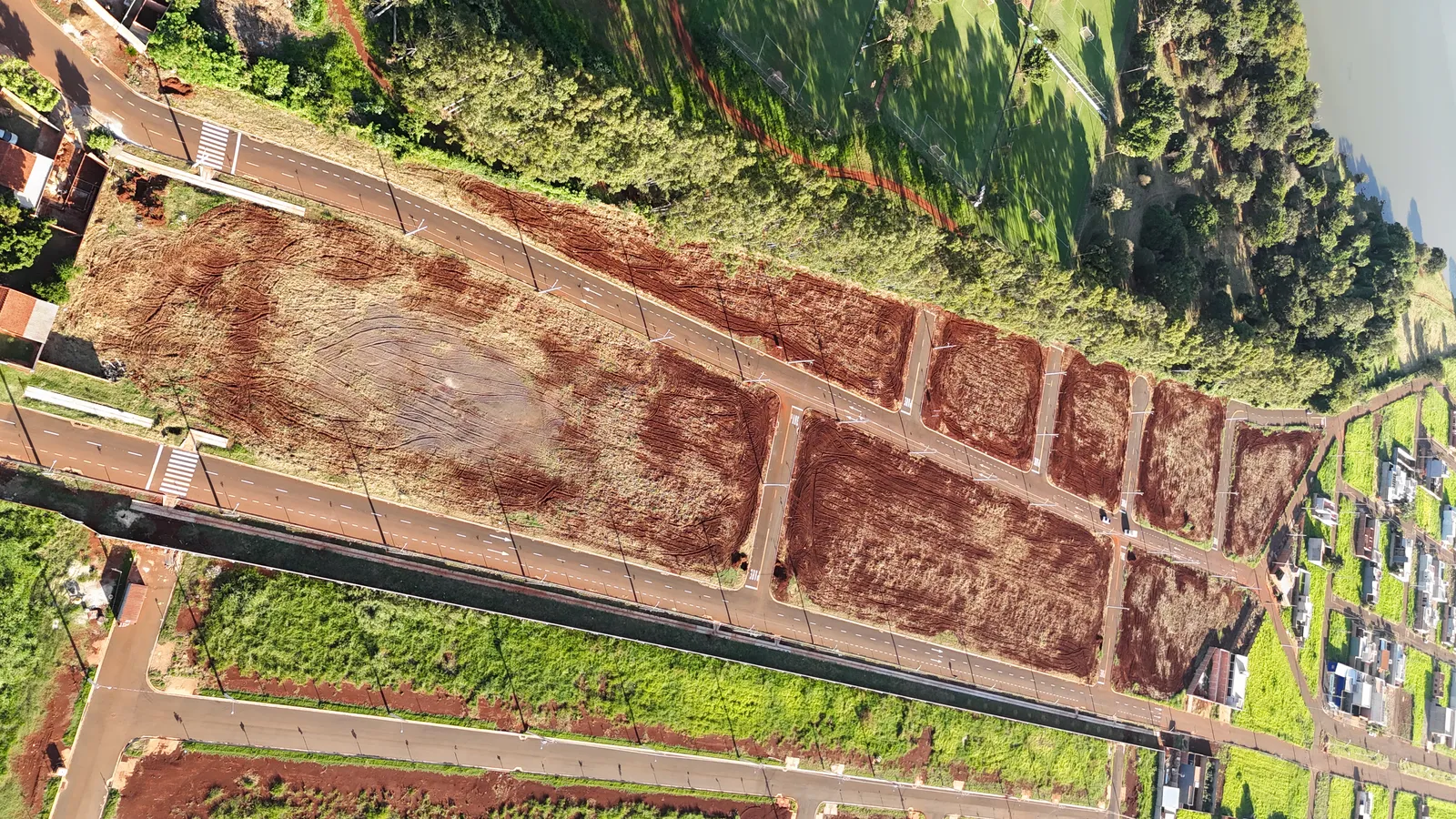 Lotes terraplenados do Ouro Branco Loteamento Aberto ao longo da rua asfaltada, prontos para construir